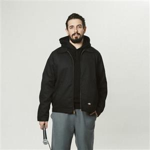 Image of comedian, Nacho Redondo, standing with mic in hand. 