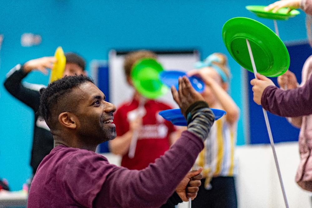 Kids trying to balance circus plates