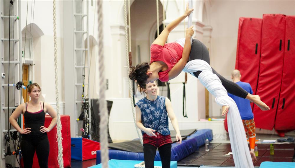 Person on aerial silks coming to a pose