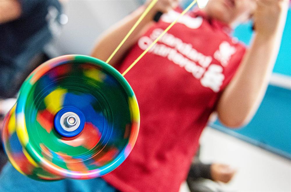 Kid balancing brightly coloured spinning toy